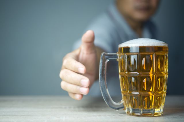 ビールが入ったジョッキをつかもうとする男性