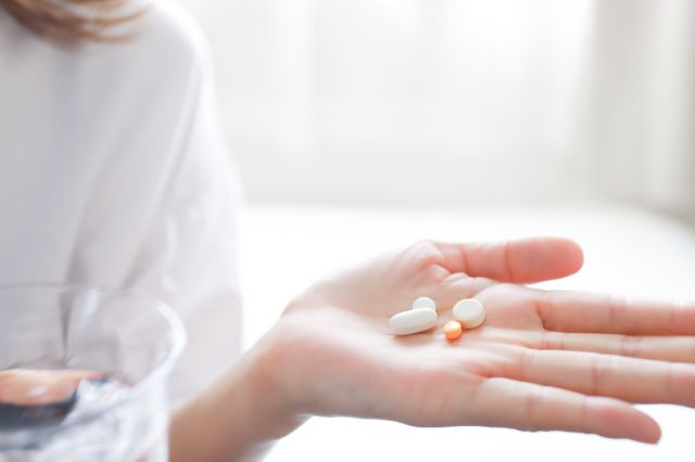 薬を手のひらに持つ女性