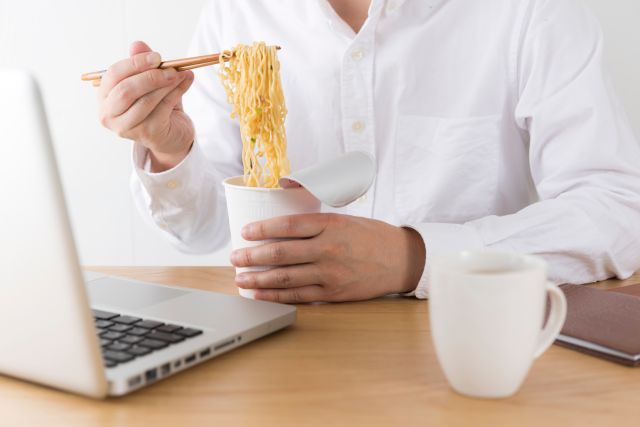 カップラーメンを食べる男性