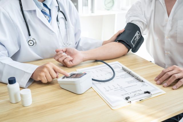 血圧を測る男性と医師