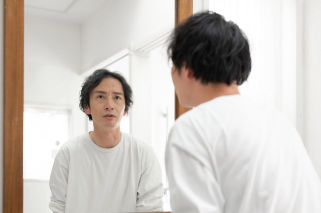 鏡を見るミドル男性