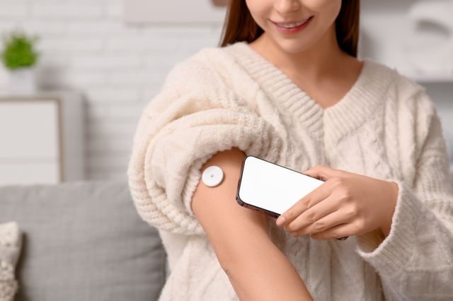 腕にセンサーを付けて測定を行う女性