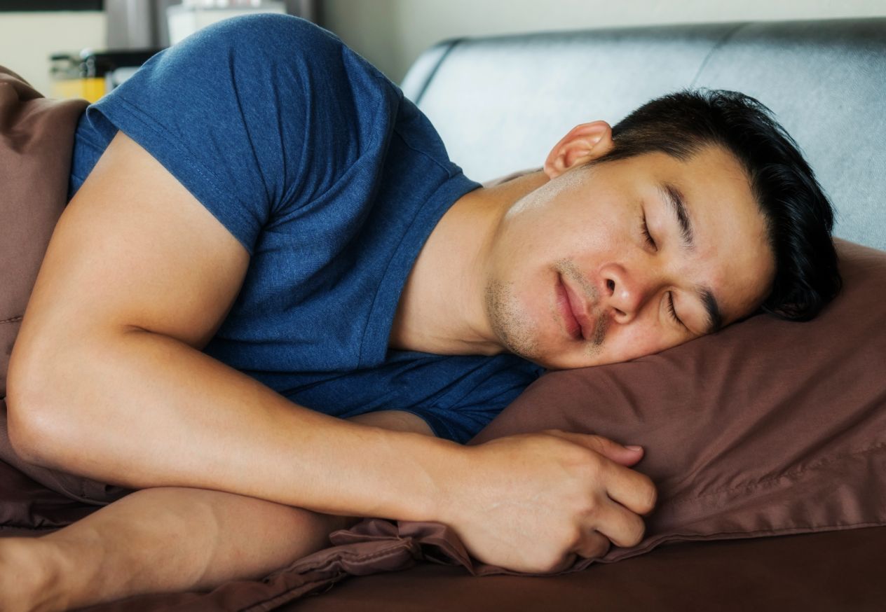 ベッドで寝る男性